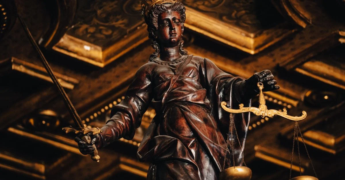 Statue détaillée de la Justice tenant des balances et une épée à l'intérieur avec des textures riches.