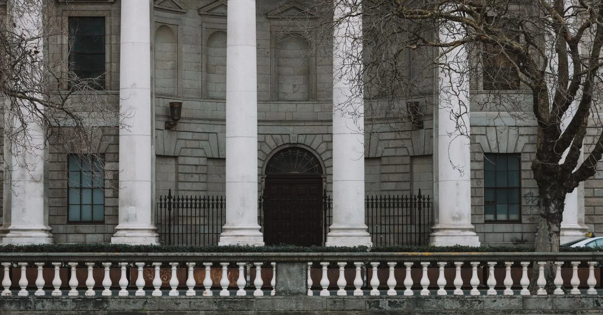 Élégante façade néoclassique des Quatre Cours de Dublin avec des colonnes blanches emblématiques.